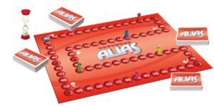 A board game setup with a red game board labeled "ALIAS" surrounded by playing pieces, decks of cards, and a sand timer, all against a white background.