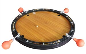 A roulette wheel with a wooden finish and orange ball deflectors spaced around its perimeter, isolated on a white background.