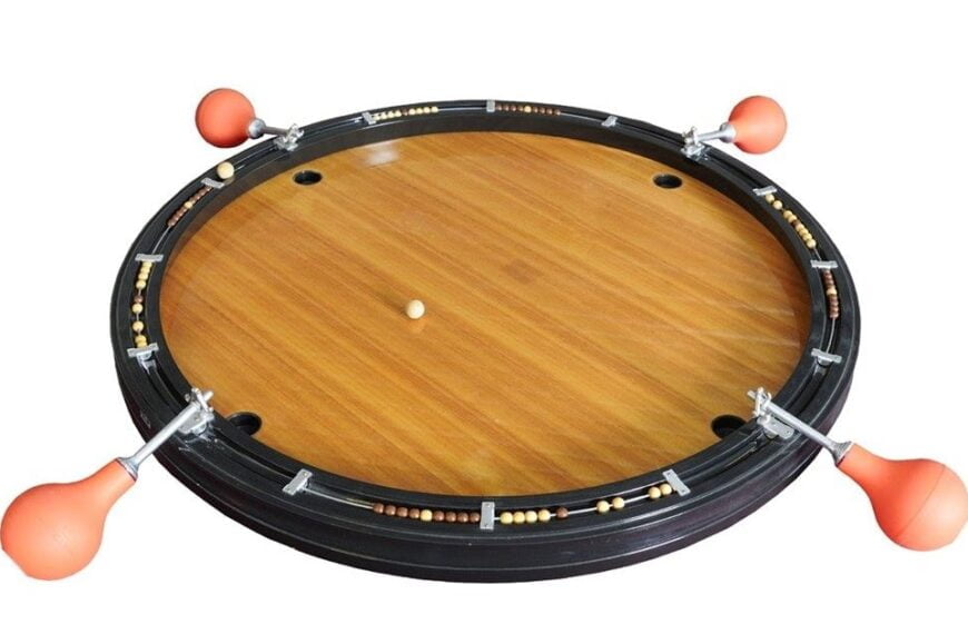 A roulette wheel with a wooden finish and orange ball deflectors spaced around its perimeter, isolated on a white background.