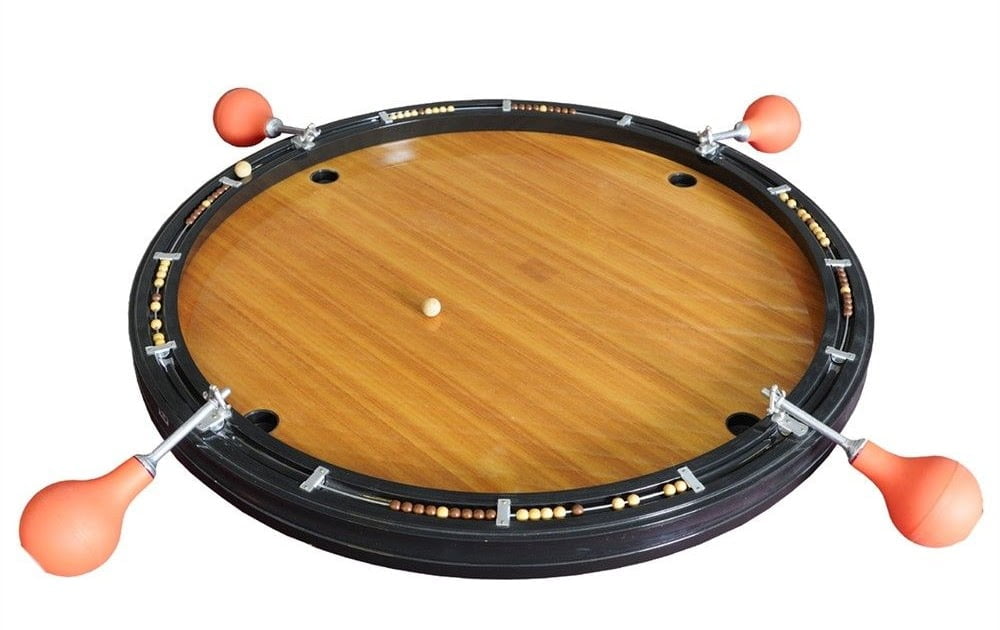 A roulette wheel with a wooden finish and orange ball deflectors spaced around its perimeter, isolated on a white background.