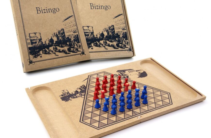 A vintage Bizingo board game with blue and red pegs on the board, and the game's box displaying the name "Bizingo" and an old city scene in the background.