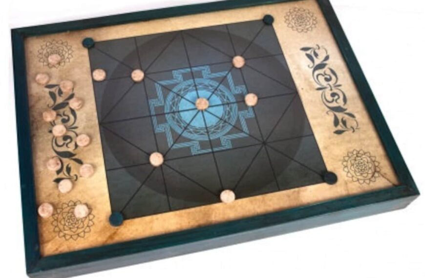 A Carrom board with black and beige patterns and designs on the surface, displayed against a white background.