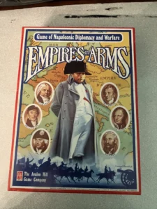 Box cover of "Empires in Arms" board game by Avalon Hill Game Company, featuring a Napoleonic era theme with illustrated portraits of historical figures and a central figure in a military uniform, set against a map background with silhouettes of cavalry at the bottom.