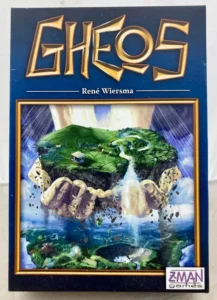 Alt text: The image displays a board game box cover with the title "GHEOS" in bold golden letters at the top. Below the title is the name "René Wiersma," presumably the game designer. The central artwork features a fantastical floating island with green landscapes and waterfalls surrounded by blue skies. On the bottom right corner, there's a logo for "Z-MAN games."