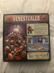 The image shows the back of the "Genestealer" board game box featuring new miniatures and psychic combat rules for the game "Space Hulk". The box art includes vivid illustrations of the game's characters engaged in combat and provides a glimpse of the miniature figurines, component layout, and some descriptive text about the game's contents. The Games Workshop and Citadel Miniatures logos, along with barcodes and item number 0334, are visible at the bottom.