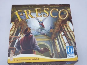 Box cover of the board game "Fresco" showing a Renaissance painting scene with artists on scaffolds, 3 expansion modules included, by Queen Games.