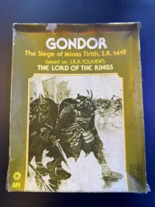 Alt text: A worn board game box for "GONDOR: The Siege of Minas Tirith, S.R. 1419," based on J.R.R. Tolkien's "The Lord of the Rings." The cover features a monochromatic illustration of a battle scene with warriors holding shields and weapons. The logo of SPI (Simulations Publications, Inc.) is visible at the bottom left corner.