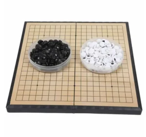 A Go board with a grid, flanked by two bowls filled with black and white game pieces.