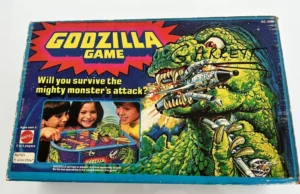 Vintage "Godzilla Game" board game box by Mattel featuring an illustration of Godzilla attacking fighter jets, with a tagline "Will you survive the mighty monster's attack?" and an inset picture of three children playing the game.