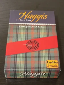 A boxed card game titled "Haggis" by Sean Ross, designed for 2-3 players, with a tartan pattern and a red band bearing a logo, along with an "Indie Boards & Cards" sticker.