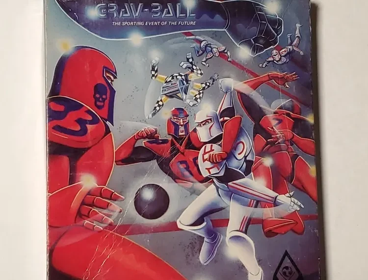 An image of a vintage "Grav-Ball" board game cover featuring stylized futuristic athletes in action around a black ball, with a cosmic backdrop and the subtitle "THE SPORTING EVENT OF THE FUTURE." The cover shows signs of wear and is partly covered by a plastic wrap.