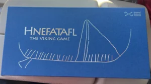 A blue box for the game Hnefatafl labeled "The Viking Game" with a white line drawing of a Viking ship, and the logo of the National Museums Scotland in the top right corner.