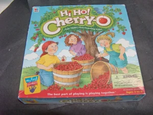 A Hi Ho! Cherry-O board game box depicting two children picking cherries from a tree and filling wooden baskets, with the tagline "Your child's first counting game" and an age recommendation for 3 to 6 years old.