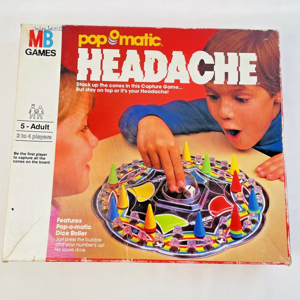 A vintage "Pop-o-matic Headache" game box featuring two children playing the board game, with colorful cones and a central dice-rolling bubble on the displayed game board.