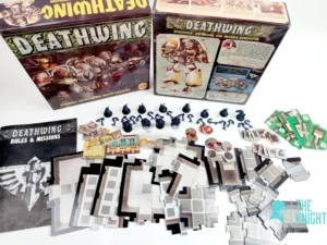 The image shows the contents of the "Deathwing" board game spread out on a surface, including its box, an instruction manual titled "Deathwing Rules & Missions", various cardboard tiles, tokens, and miniature blue figures. The game is identified as a "Space Hulk Expansion and Mission Generator". A logo with the text "The Knight" is present in the bottom right corner.