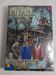 Board game cover titled "IMPERIAL" with artwork of three men in historical dress, examining a map with a ship and industrial backdrop, "Designer: Mac Gerdts" written at the top, and "Rio Grande Games" logo at the bottom.