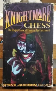 A worn board game box titled "KNIGHTMARE CHESS" with subtitle "The Original Game of Chaos on the Chessboard." The image features a stylized jester with a sinister smile against a dark backdrop with the text "STEVE JACKSON GAMES" at the bottom.