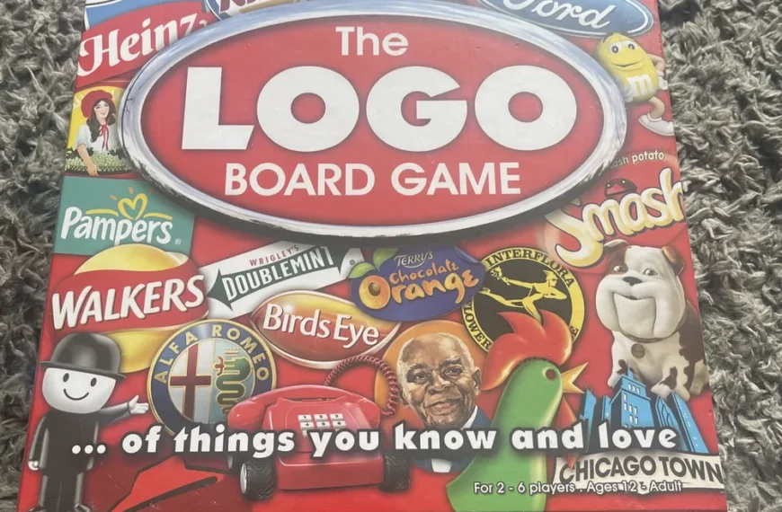 A board game box labeled "The LOGO BOARD GAME" featuring a collage of various brand logos and mascots, with the subtitle "...of things you know and love" for 2-6 players, ages 12 to adult, placed on a textured gray surface.