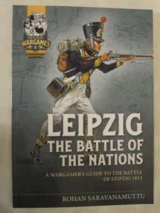 Book cover titled "LEIPZIG THE BATTLE OF THE NATIONS - A Wargamer's Guide to the Battle of Leipzig 1813" by Rohan Saravanamuttu. Features an illustration of a soldier in early 19th-century uniform aiming a rifle, with a map background and the logo "HELION WARGAMES 8" in the top left corner.