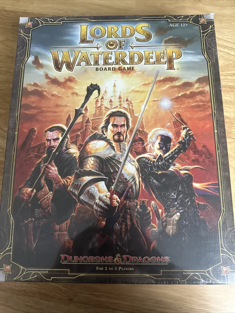 A "Lords of Waterdeep" board game box featuring illustrated fantasy characters prepared for battle, with the Dungeons & Dragons logo at the bottom, indicating that the game is for 2 to 5 players and suitable for ages 12 and up.