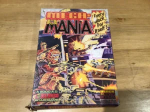 A board game named "MEGA-MANIA" lies on a wooden surface, featuring vivid illustration of futuristic police in combat, with the text "Every block for itself", and "A 2000 A.D. Judge Dredd boardgame expansion set by Richard Halliwell" on the cover.