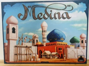 Box cover art for the board game "Mesa", depicting an illustrated Middle Eastern cityscape with domed buildings, minarets, and figures engaged in various activities, under an ornate title design.