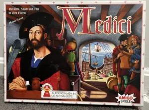Alt text: The image shows a board game box titled "Medici." The artwork features a Renaissance-style portrait of a man in the foreground with the interior of a merchant ship and a small window view of the sea in the background. A sticker indicating an award from "Spiel des Jahres 1995" is visible. The box also includes the logos of Amigo Spiele and text in German that translates to "Wealth, Power, and Honor in Old Florence."