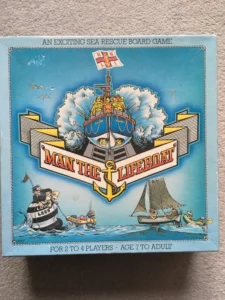 Board game box titled "MAN THE LIFEBOAT" featuring an illustrated nautical rescue scene with a lifeboat, sailors, and a sailboat on a stormy sea, labeled as an exciting sea rescue game for 2 to 4 players, ages 7 to adult.