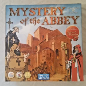 The image shows the board game cover for "MYSTERY of the ABBEY" by Bruno Faidutti and Serge Laget, including cartoon-style illustrations of two monks and an abbey building. The cover also features the Days of Wonder logo and award stickers for Spiel des Jahres and Tric Trac.