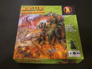 A board game titled "Monsters Menace America" by Avalon Hill is depicted, featuring artwork of a large creature attacking a city, with military forces in the foreground. The box highlights it as a game of mayhem and mass destruction for 2-4 players, ages 12 and up, with a playing time of around 90 minutes.