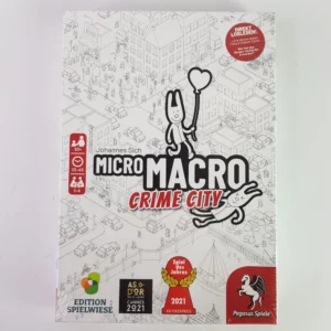 Board game cover for "MicroMacro: Crime City" showing a black and white illustrated cityscape with cartoon detective characters, multiple award badges, and the game's title in bold lettering.