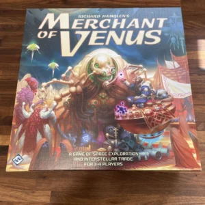 Board game "Merchant of Venus" by Richard Hamblen, a space exploration and interstellar trade game for 1-4 players, artwork featuring colorful alien scenery and space crafts, displayed on a wooden surface.