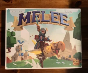 A board game box cover for 'MELEE,' showing an animated knight riding a large bird-like creature, with cartoon-style castles and floating islands in the background. The game credits "Rikki Tahta" and "La Mame Games," with the logo of "Indie Boards & Cards" at the bottom right.