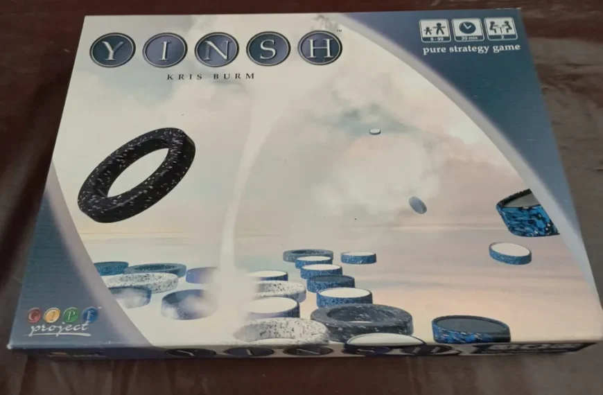 A photo of the board game "YINSH" by Kris Burm, displaying the game's box which features the game's title, the author's name, various playing pieces, and labels indicating it is a pure strategy game from the GIPF project series.