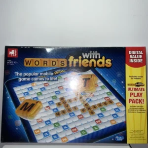 A boxed board game of "Words with Friends" with a tagline "The popular mobile game comes to life!" and a note on the side indicating a digital value "Ultimate Play Pack" included inside.