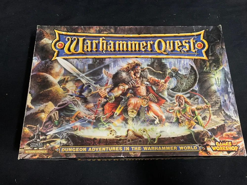 Box cover of "Warhammer Quest" board game featuring fantasy artwork with warriors and monsters, and logos for Citadel Miniatures and Games Workshop.