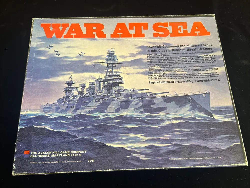 Vintage "War at Sea" board game cover with a dramatic illustration of naval ships and airplanes at sea, along with promotional text and the Avalon Hill Game Company logo.