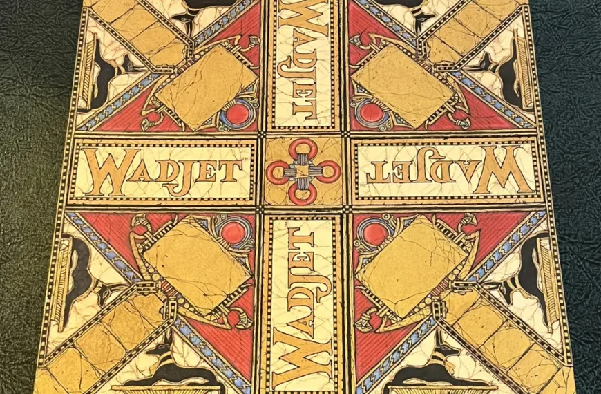 Ornate, square board game box with "WADJET" text, Egyptian-themed illustrations, and vibrant red, gold, and blue colors on a textured black background.