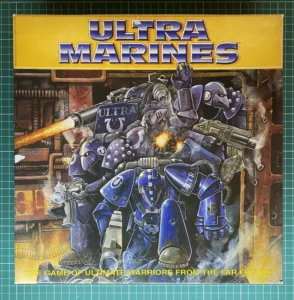 Alt text: The image shows the cover art for a game titled "ULTRAMARINES," featuring illustrated futuristic armored warriors in blue and purple with the tagline "The Game of Ultimate Warriors from the Far Future." One of the warriors is firing a weapon with a visible blast. The background hints at an industrial setting.