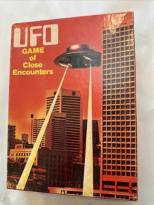 Vintage board game cover "UFO Game of Close Encounters" depicting a UFO with beams of light over a cityscape.