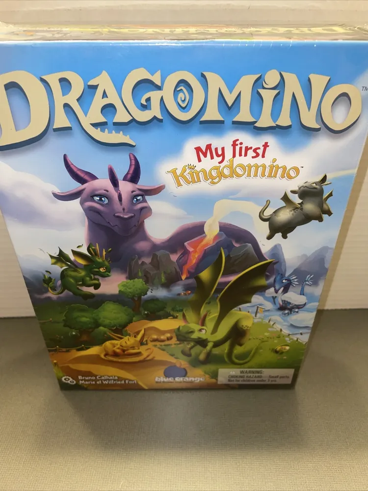 A sealed board game box for "Dragomino: My first Kingdomino" with colorful cartoon dragons and a fantasy landscape illustrated on the cover.