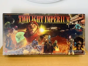 A board game box for "Twilight Imperium Third Edition" featuring a collage of various alien species, space ships, and distant planets, with the tagline "PAX MAGNIFICA BELLUM GLORIOSUM" below the title.