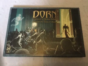 A tabletop game box titled "DORN: Výprava za Bránou Osudu / Beyond the Gate of Doom," featuring fantasy artwork with warriors fighting skeletons in front of a large gate where a spectral figure and a character holding a staff appear.