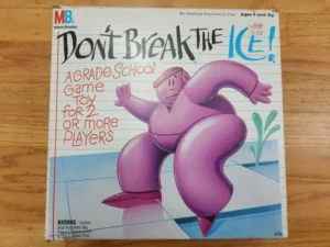 A box cover of the "Don't Break the Ice" game by Milton Bradley, featuring cartoon artwork of a person in a pink suit cautiously stepping on ice with the title in large blue and pink letters, and a description that reads "A Grade School Game Toy for 2 or More Players," with a warning label for small parts and an age recommendation of 5 and up. The price tag shows $6.99.