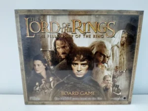 A "The Lord of the Rings: The Fellowship of the Ring" board game box, featuring images of the main characters and the movie's logo, designed for ages 8 and up, 2-5 players.
