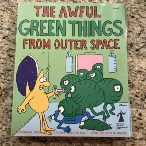 The image shows a board game box titled "THE AWFUL GREEN THINGS FROM OUTER SPACE" with cartoonish artwork of a yellow, startled-looking character facing green, blob-like monsters with eyes on stalks. Below is a tagline "A PREPOSTEROUS SPACE GAME FOR 2 PLAYERS, AGES TO ADULT, PLAYING TIME 30 TO 60 MINUTES." There is also the TSR Games logo with a location in Lake Geneva, WI.