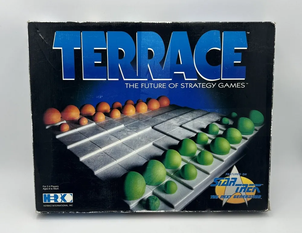 A board game box reading "TERRACE THE FUTURE OF STRATEGY GAMES" with an image of a strategy game board and pieces in two colors, and a logo indicating it is featured on "STAR TREK THE NEXT GENERATION."