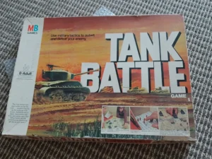 A worn "Tank Battle" board game box by MB Games for ages 8-adult, featuring images of tanks and gameplay with an orange and sunset sky background.