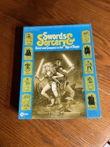 A board game called "Swords & Sorcery" on a wooden surface, featuring cover art with fantasy characters and marked with game design credits.