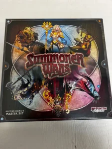 Alt text: Box cover art for "Summoner Wars Second Edition Master Set" by Plaid Hat Games, featuring stylized fantasy characters, including a female mage with a staff, a knight with a sword, and creature-like warriors engaged in battle.